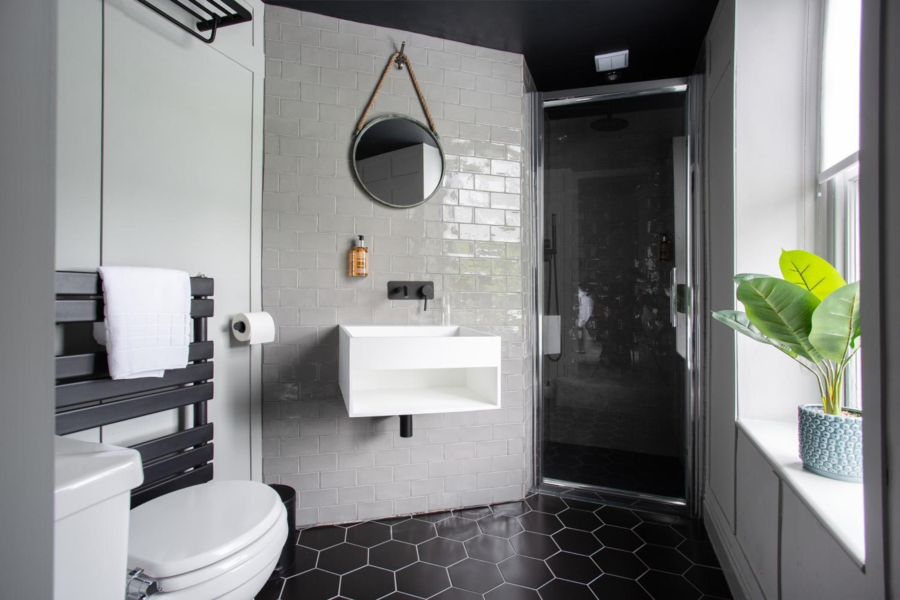 A modern bathroom with a toilet, sink, and shower.