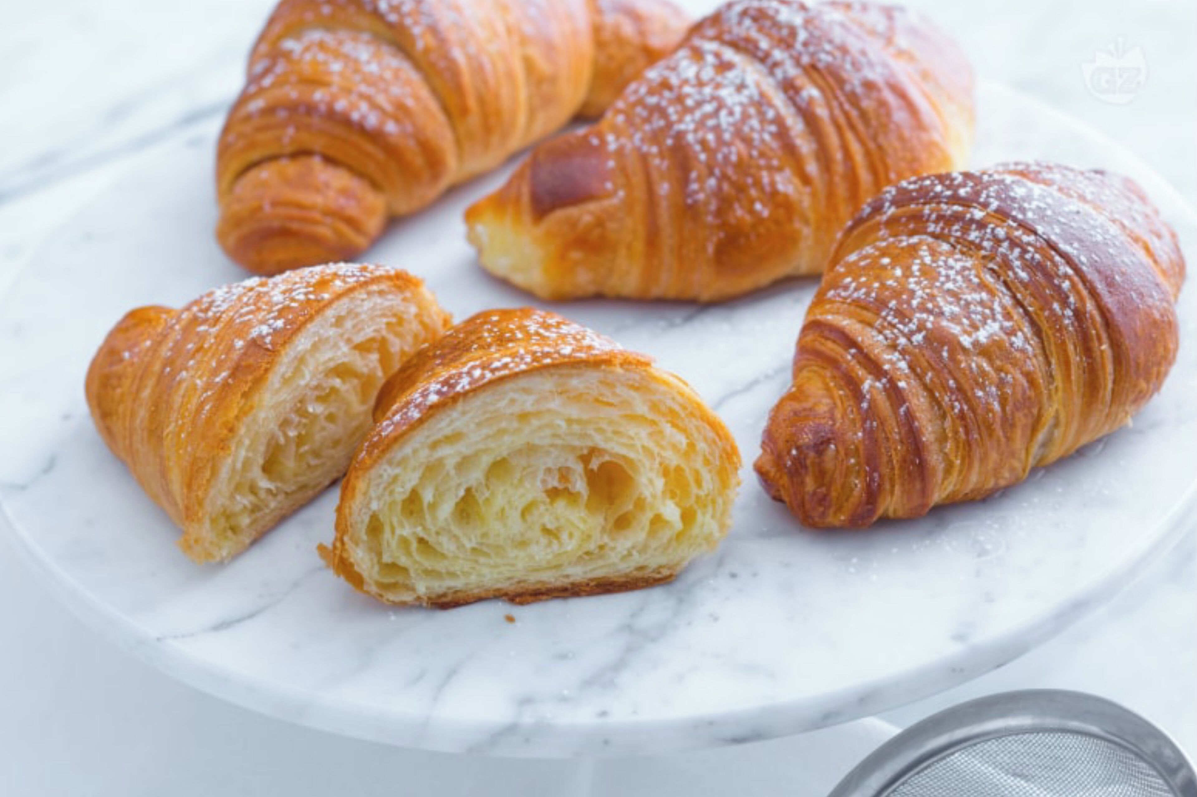 Een bord met croissants op een marmeren oppervlak.