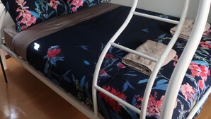 A bunk bed with floral bedding and a towel on the lower bunk. - Mud Crab Motel (Derby)