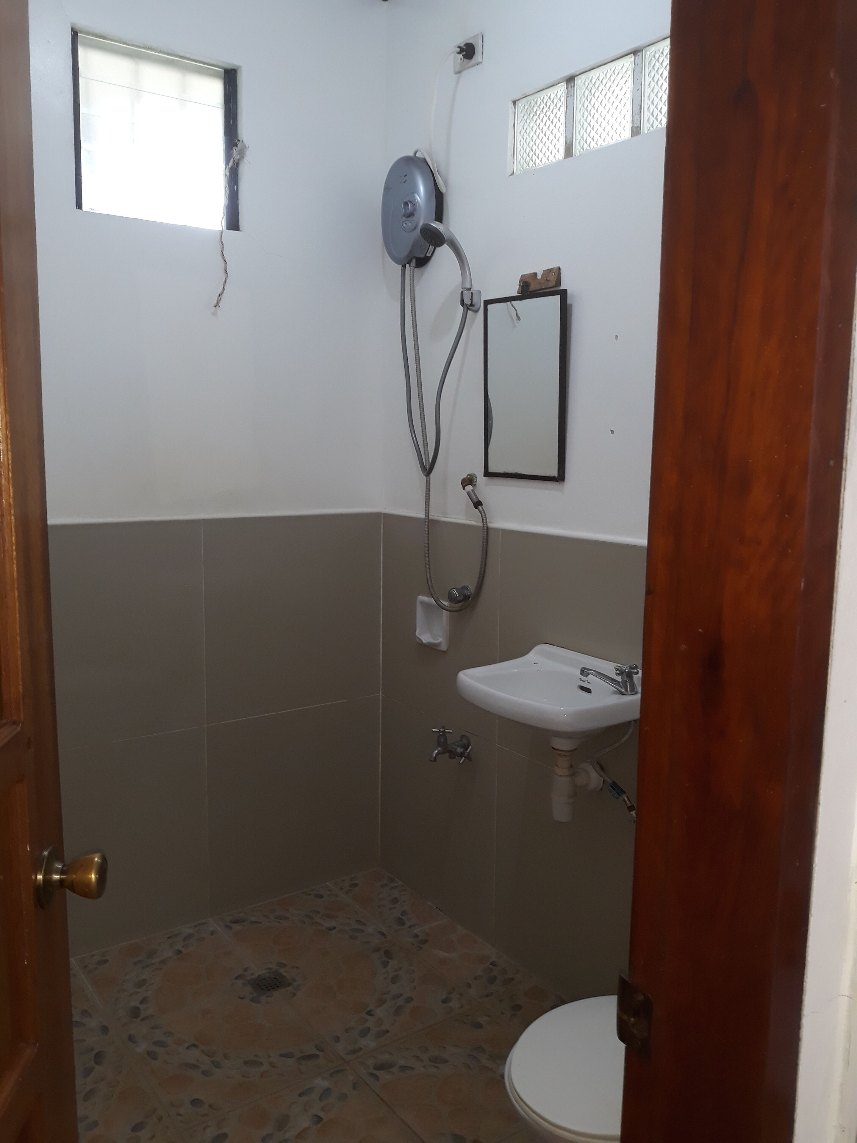 A bathroom with a shower, sink, and toilet.