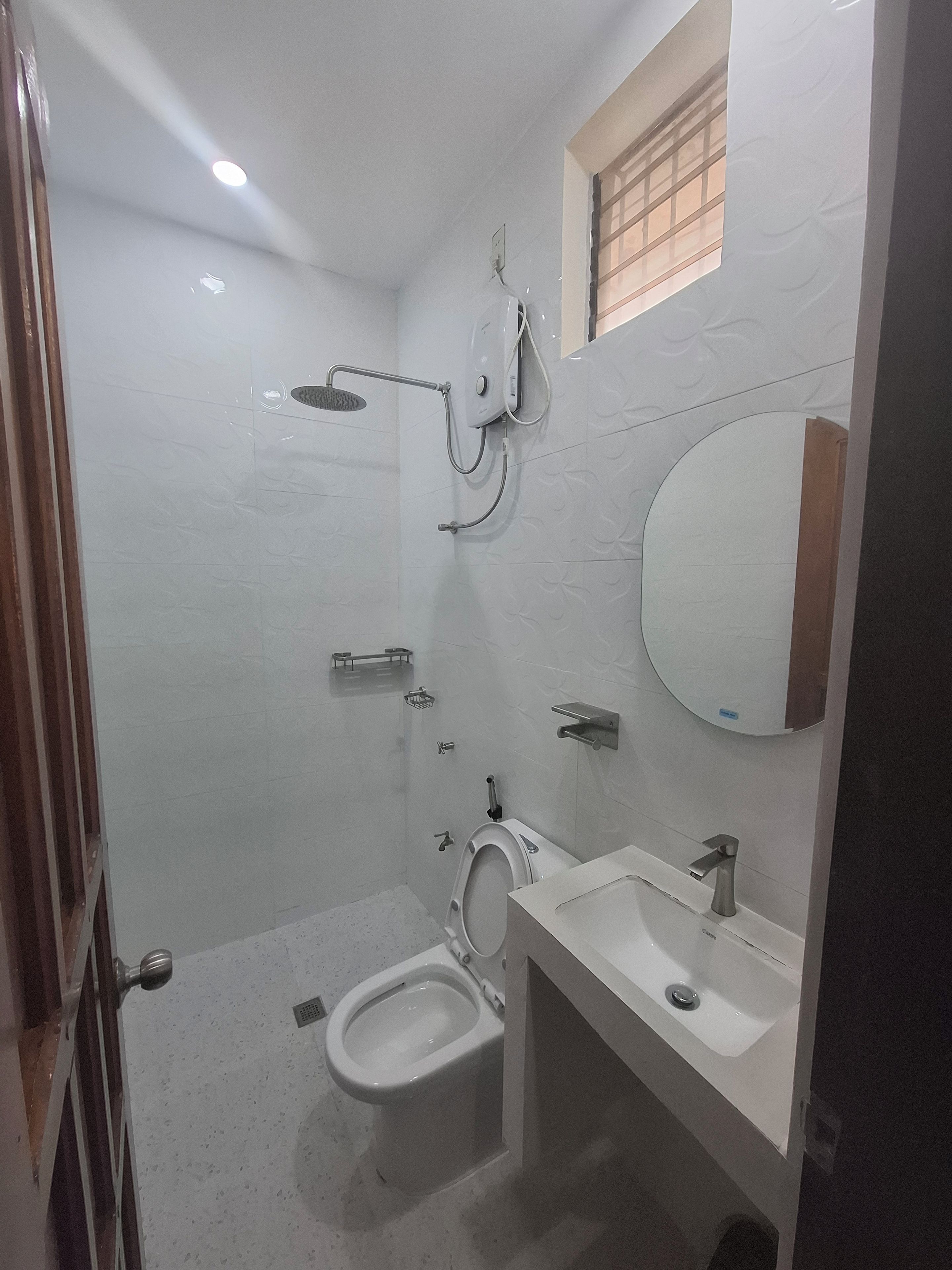 Un bagno con servizi igienici, lavandino, doccia e specchio.
