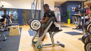 A gym with exercise equipment, wooden flooring, and a TV on the wall. - ICV SleepWell (Vra)