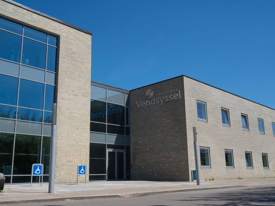 A modern building with large windows and a sign reading "Vendsyssel".