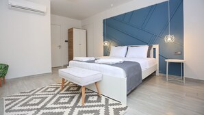 Une chambre à coucher moderne avec un lit, des tables de chevet, un banc et un tapis à motifs.