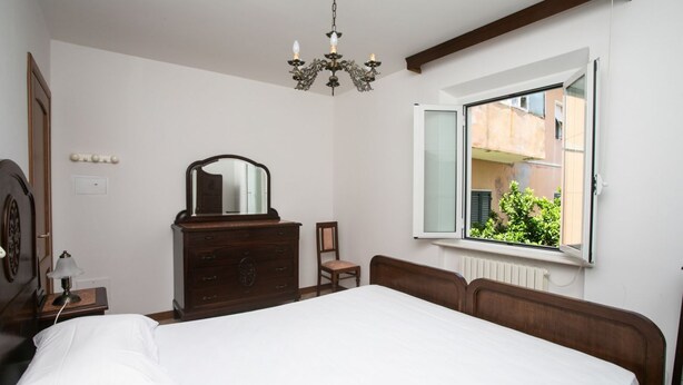 A bedroom with a bed, dresser, mirror, chair, and a window with an open shutter. - S202 - Sirolo, new two-room apartment convenient to services (Sirolo)