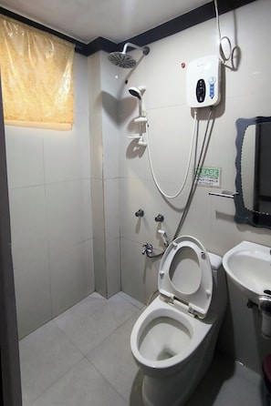 A small, compact bathroom with a toilet, bidet, and sink. - Jace's Travellers Inn (El Nido)