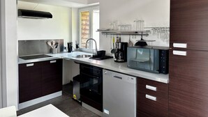 A modern kitchen with a dishwasher, oven, microwave, and a coffee maker. - Ecocoon Cottage – Sleeps 4 – 2 Bathrooms – Heated Indoor Pool (Arques)
