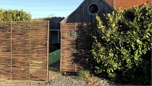A rustic wooden gate with a circular opening, a green door, and a sign that reads "Ecovon." - Ecocoon Cottage – Sleeps 4 – 2 Bathrooms – Heated Indoor Pool (Arques)
