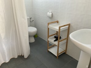 Ein Badezimmer mit Toilette, Ablagefläche und Waschbecken.