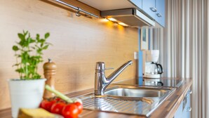 A modern kitchen with a stainless steel sink, wooden countertop, and a potted plant. - Large apartment - very illuminated, Wi-Fi, ocean view, close to the beach and ni (Wittdün)