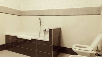 A bathroom with a bathtub, a toilet, and a shower.