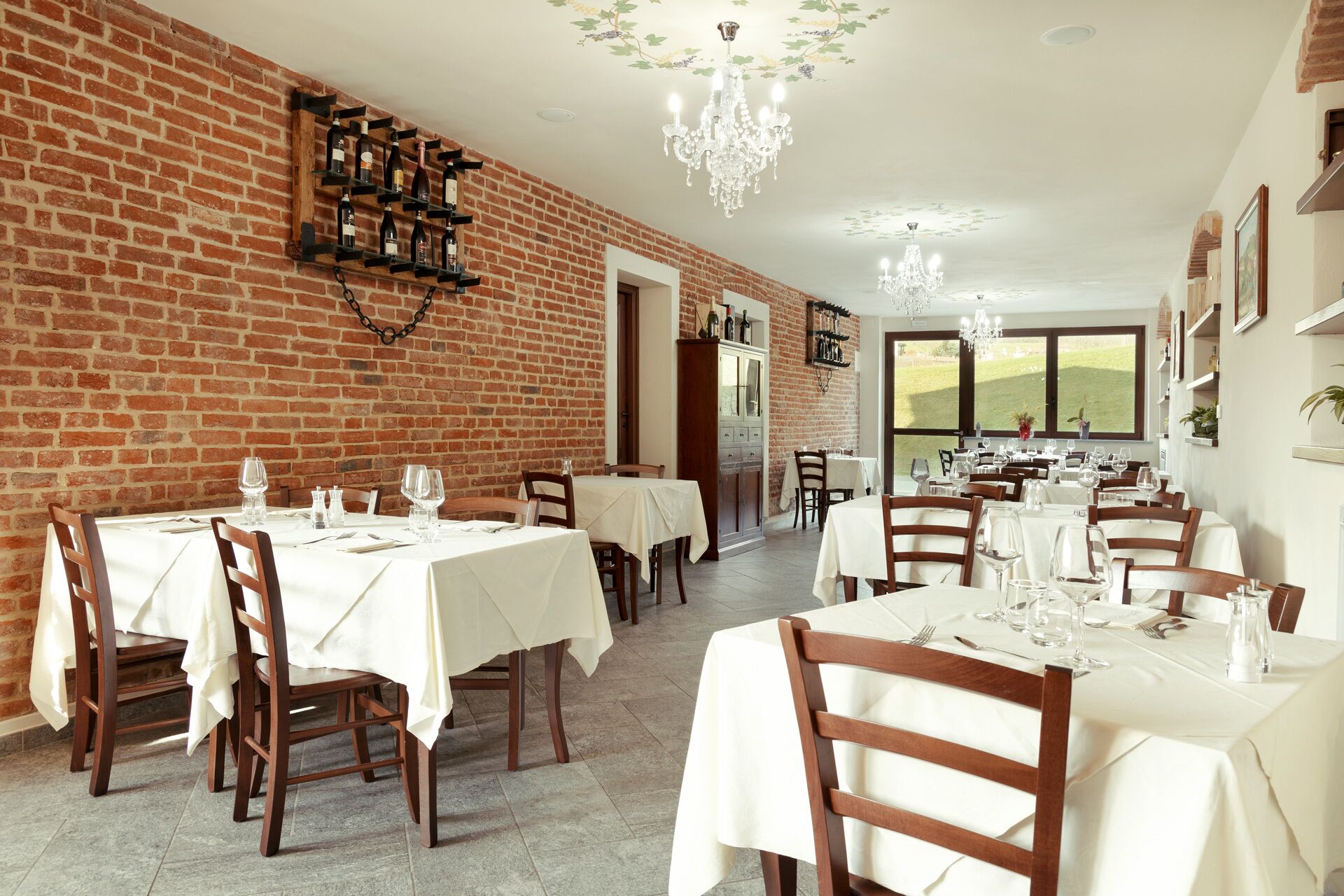 Un restaurante con paredes de ladrillo, manteles blancos y sillas de madera.