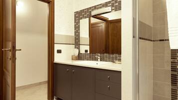Ein Badezimmer mit Waschbecken, Spiegel und Schrank.