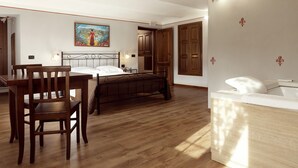 Una habitación con piso de madera, una cama con cabecera, una mesita de noche, una silla, un cuadro en la pared y una puerta.