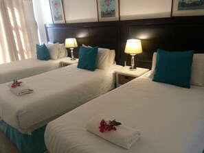A hotel room with two single beds, each with a pillow and a small table with a lamp. - Saldanha Bay Inn (Saldanha)
