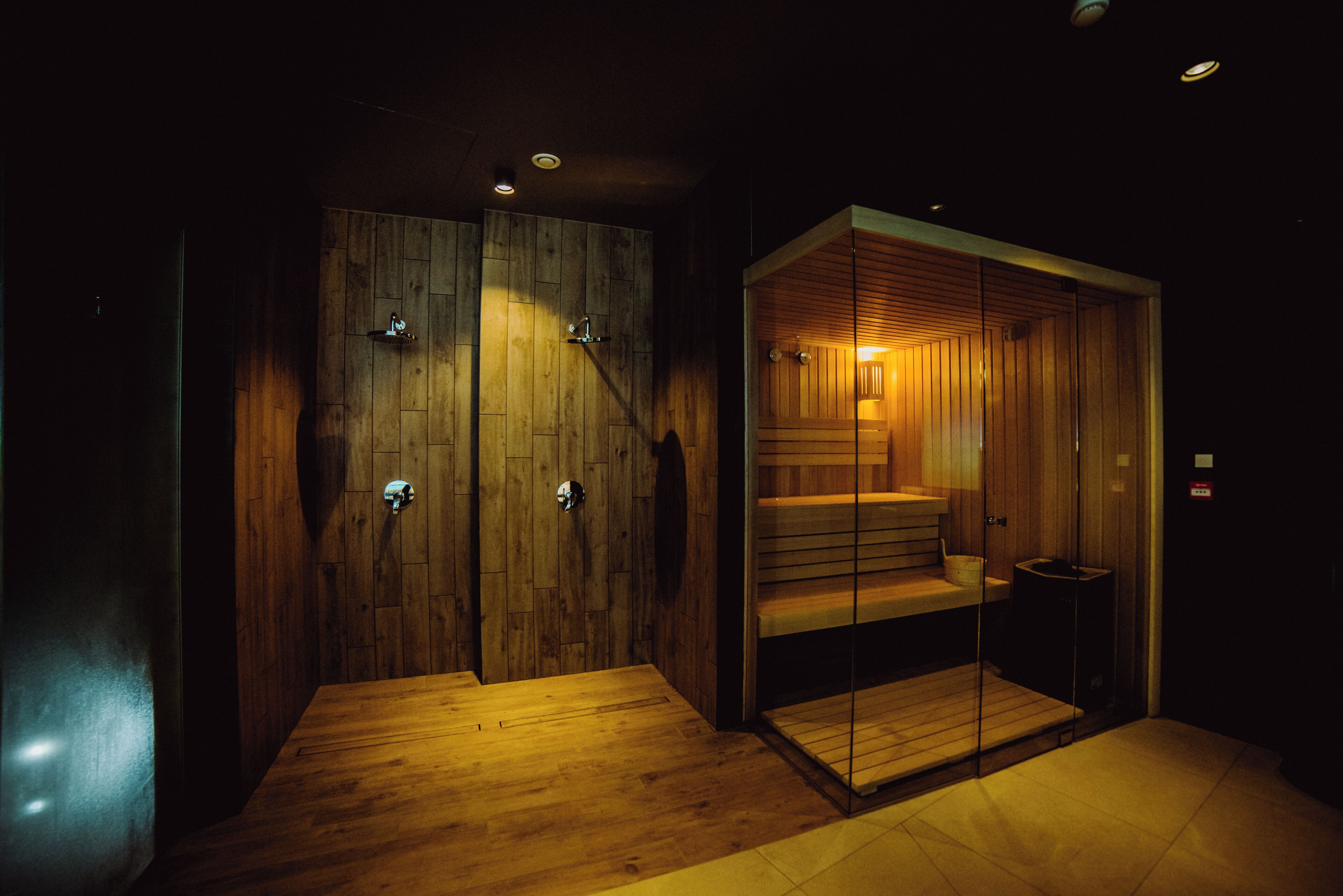 Un interior moderno con paredes de madera, un separador de vidrio y una pequeña zona de estar.