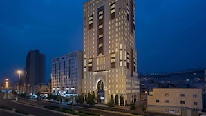 Un hotel de varios pisos con una entrada central destacada, grandes ventanales y un diseño arquitectónico moderno.