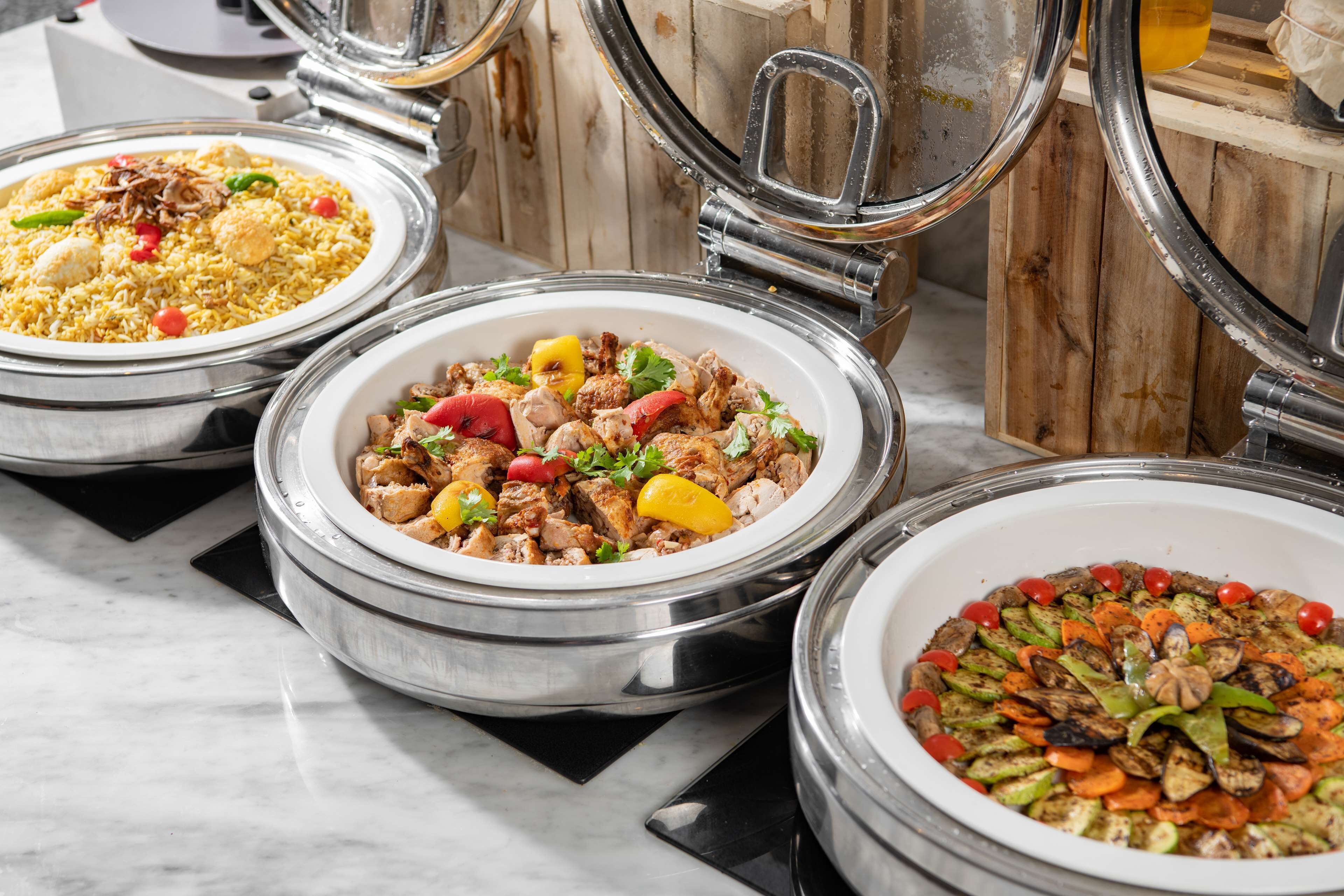 Three covered food dishes with lids, placed on a marble surface.