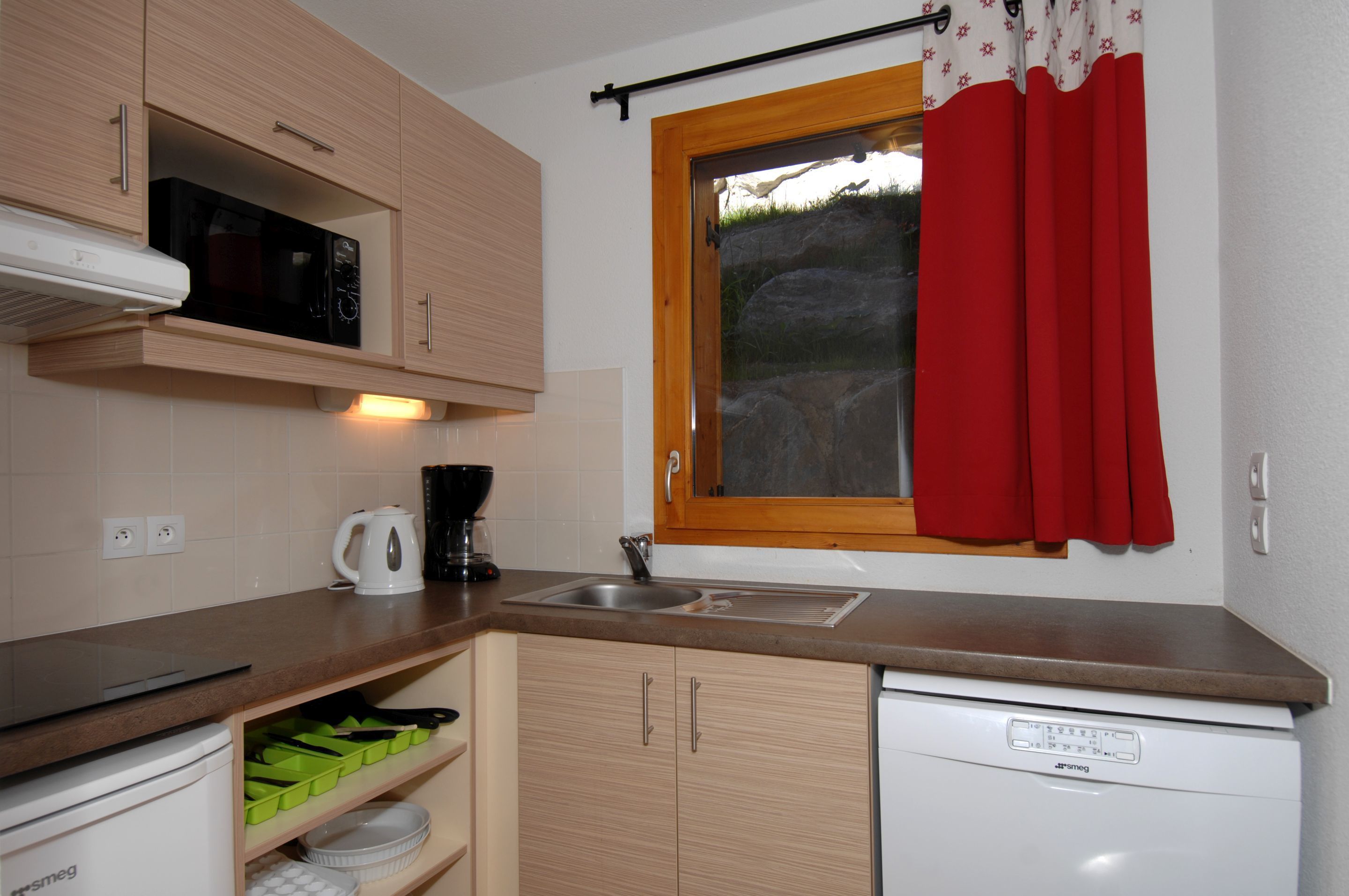 A compact kitchen with a microwave, coffee maker, and dishwasher.
