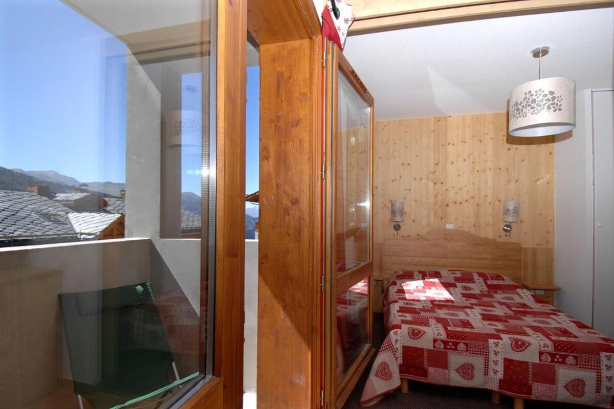 Une chambre à coucher avec un lit, une fenêtre et un mur en bois.