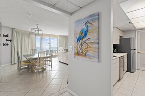 A modern kitchen with white cabinets, a refrigerator, and a countertop.