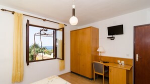A bedroom with a bed, a desk, a chair, a wardrobe, a television, and a window with curtains. - Apartments Villa Ana - Dingac (Orebic)