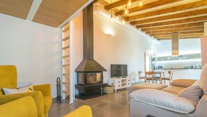 A modern living room with a fireplace, yellow sofas, a TV, and a kitchen in the background. - PARATGE DE SON TONIET - Apartment with private pool in Buger. Free WiFi (B��ger)
