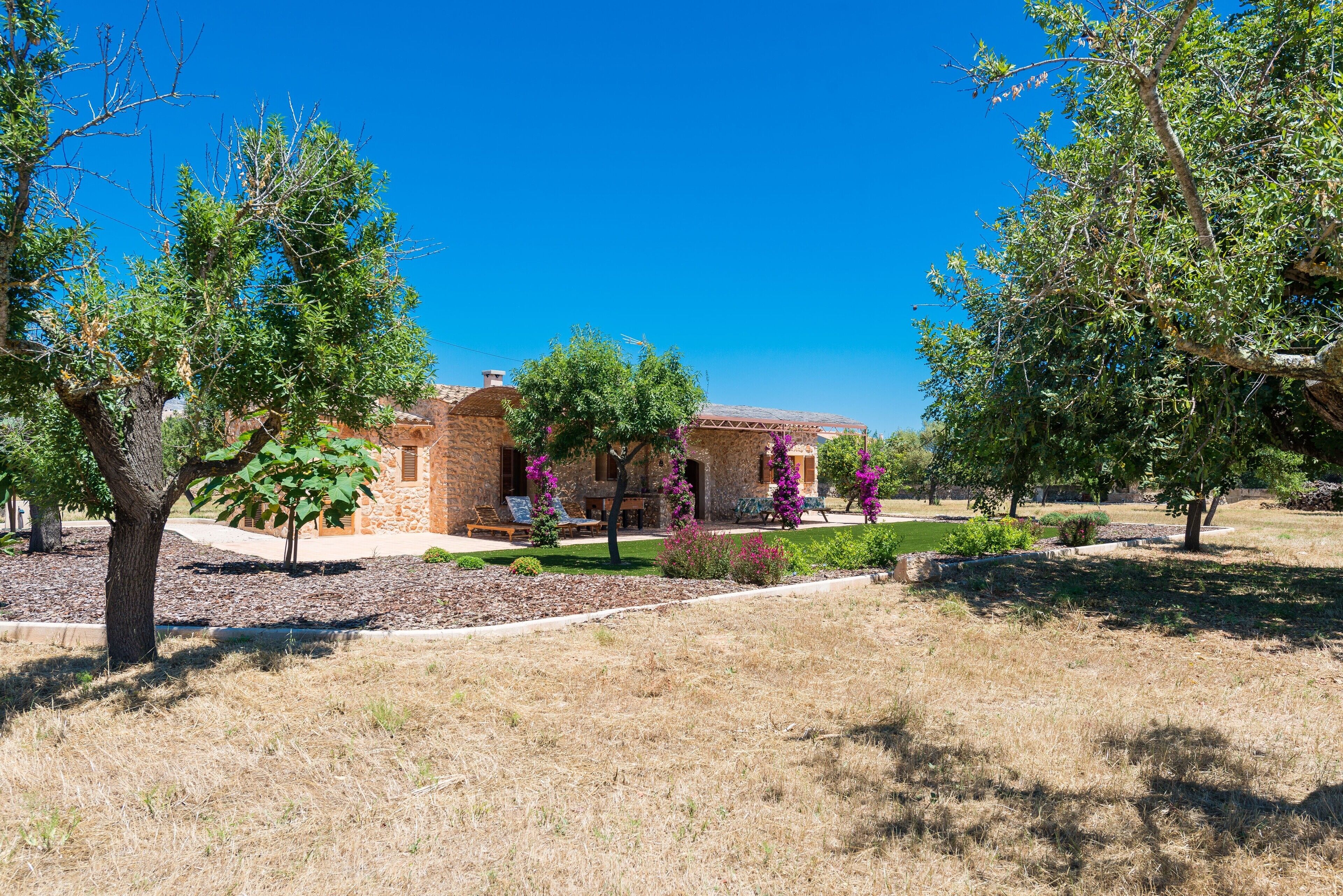 Una casa de ladrillo con un patio y un jardín.