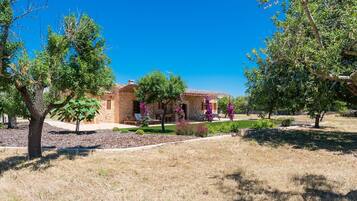 Una casa de ladrillo con un patio y un jardín.