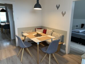 Un espace de vie compact comprenant un coin repas, un canapé et un lit.