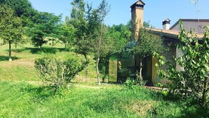 A house with a chimney, surrounded by lush greenery and trees. - La Valle (Giavera del Montello)