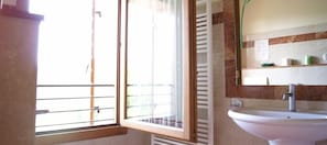 A bathroom with a window, a sink, and a mirror. - La Valle (Giavera del Montello)
