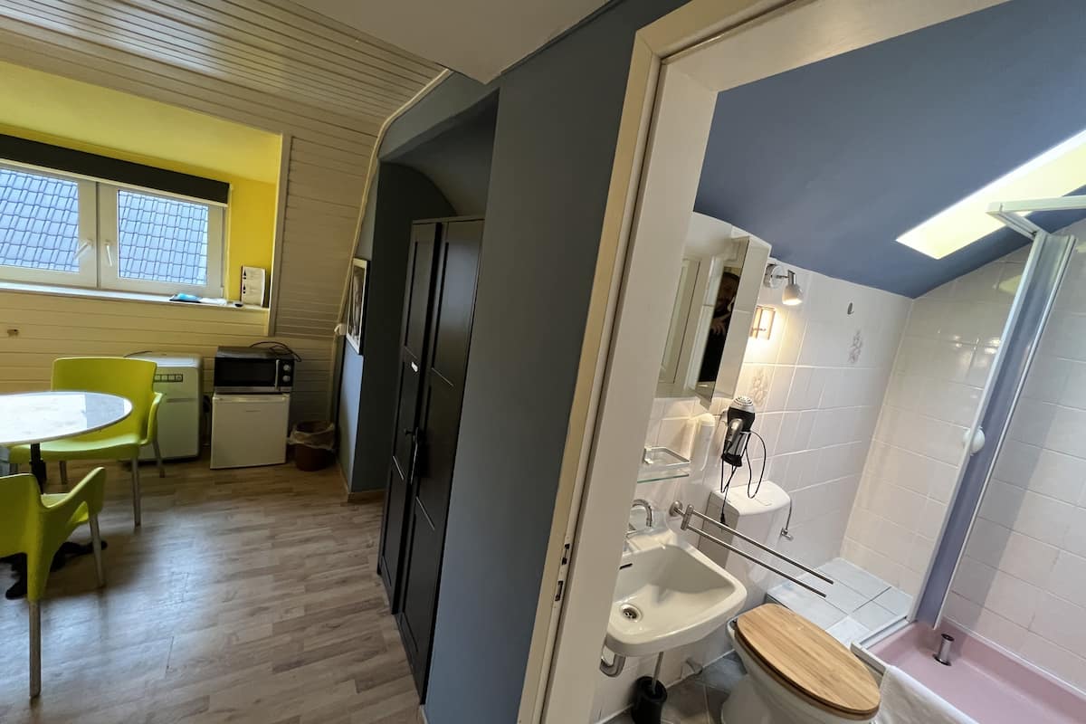 Pieni, käytännöllinen keittiö, jossa on ruokailutila, pesuallas ja wc.