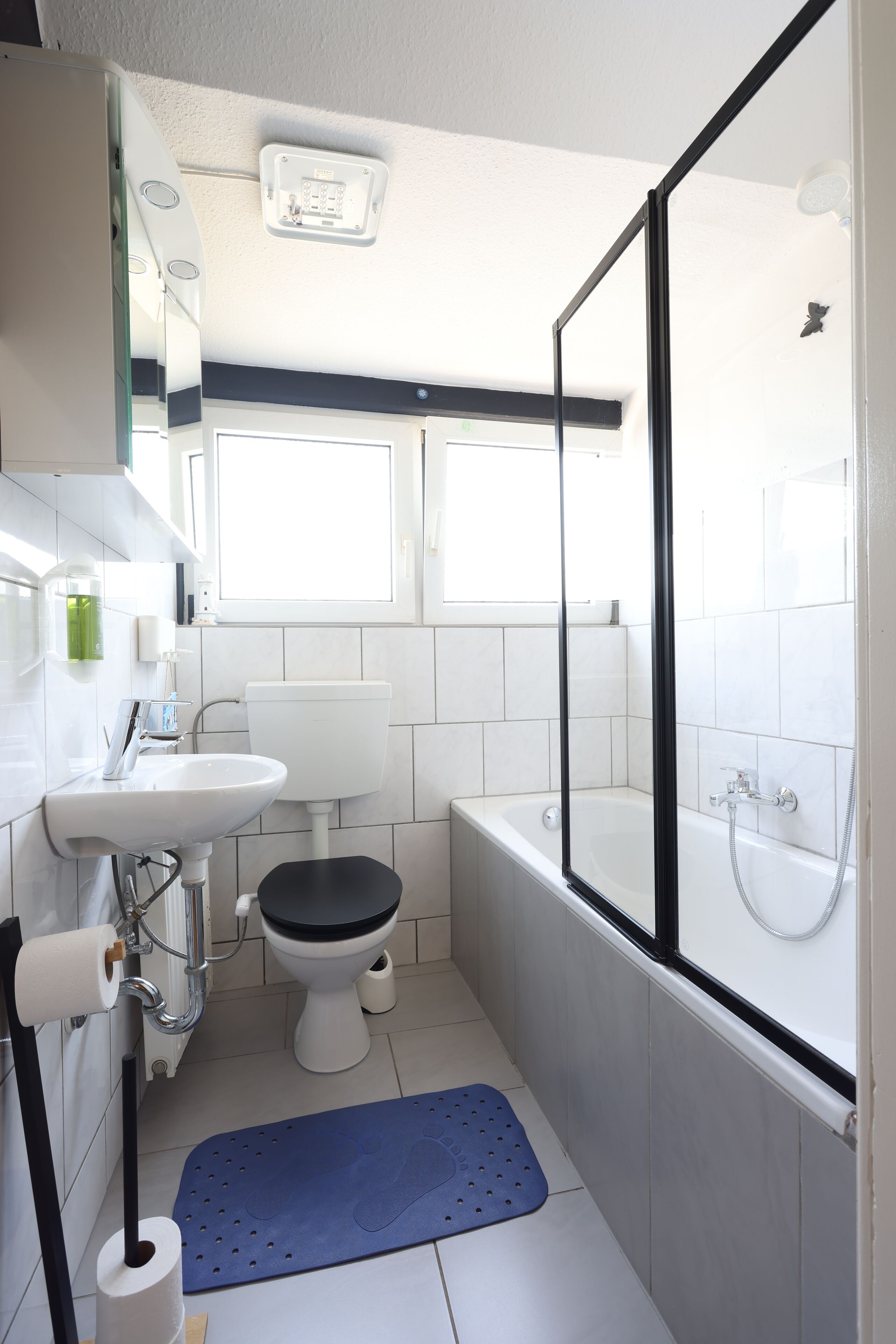 A compact bathroom with a toilet, sink, and bathtub.