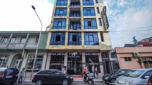 Un edifici de diversos pisos amb un rètol que indica 'Ajara Palace Hotel' i 'Ajara Pub' a la planta baixa.