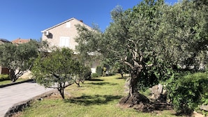Uma casa de pedra com telhado inclinado e uma pequena varanda.