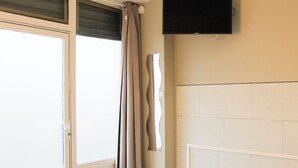 A bathroom with a shower, a toilet, and a sink. - Souplex - 4P - Batignolles (Paris)