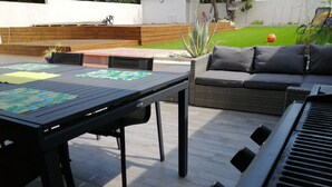 An outdoor patio with a table, chairs, a sofa, and a keyboard. - House villas with swimming pool on Nîmes (Nîmes)