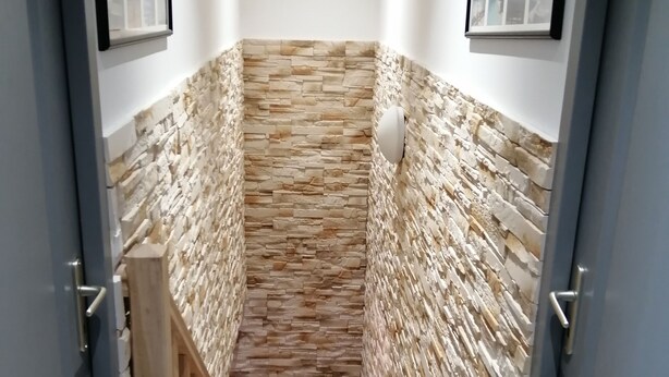 A narrow stairway with stone walls and wooden railings, leading to a landing with framed pictures on the walls. - House villas with swimming pool on Nîmes (Nîmes)