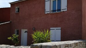A red building with white shutters and a stone wall in front. - House villas with swimming pool on Nîmes (Nîmes)