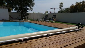 A wooden deck with a swimming pool, lounge chairs, and a hammock. - House villas with swimming pool on Nîmes (Nîmes)