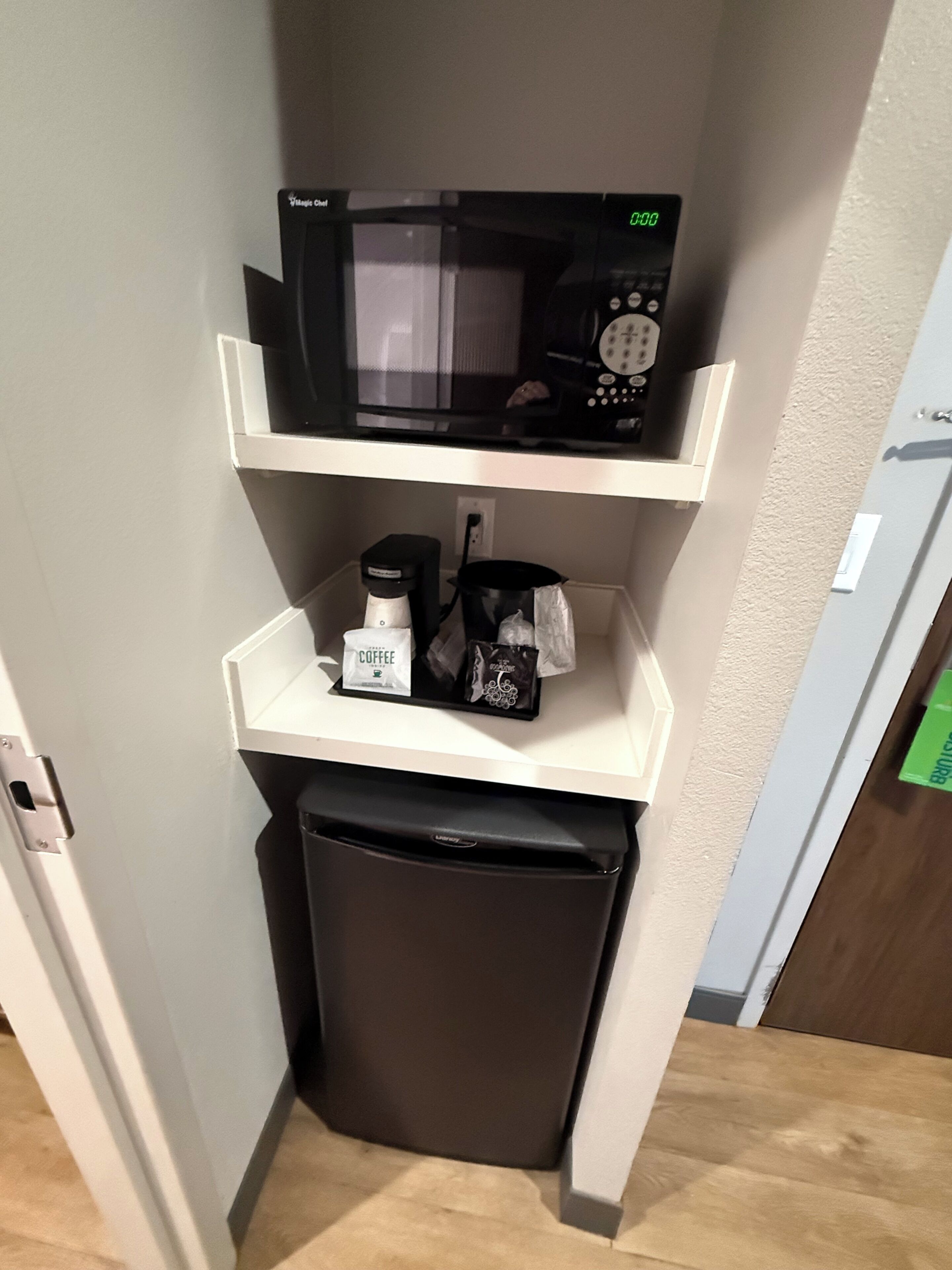 Une petite cuisine équipée d’un four à micro-ondes, d’une machine à café et d’un petit réfrigérateur.