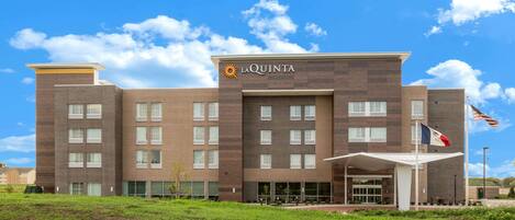 Un hotel moderno con tejado plano, varias ventanas y una bandera.