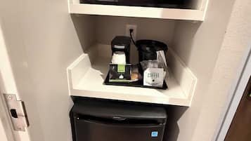 A compact kitchenette with a microwave, coffee maker, and a small refrigerator.