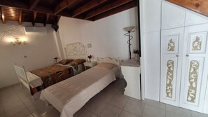 A bedroom with a bed, bedside tables, a nightstand, a lamp, and a wardrobe with decorative doors. - Castellino - Traditional Loft Apartment with balcony for 5 people (Faliraki)