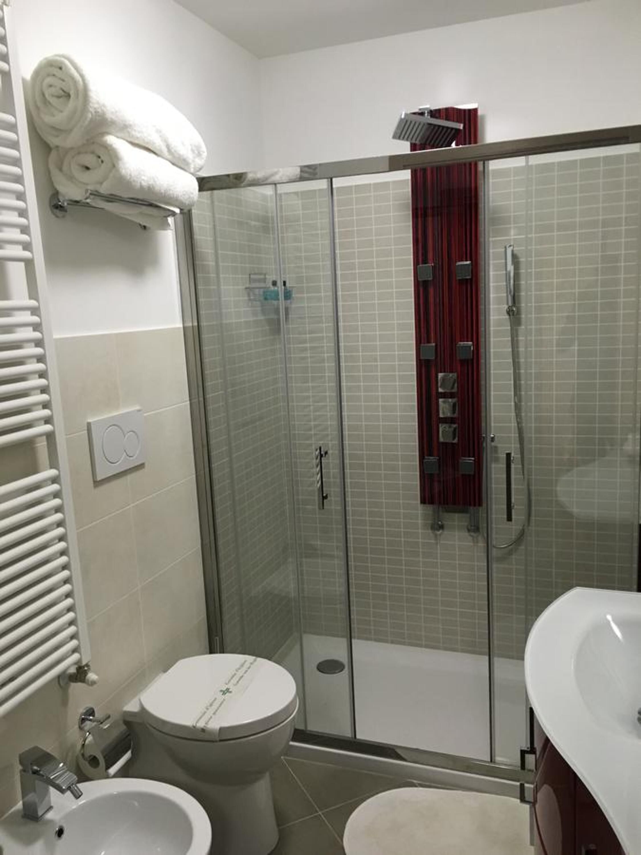 Une salle de bain avec une douche à parois de verre, des toilettes et un lavabo.