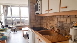 Eine kleine Küche mit Mikrowelle, Spüle und Arbeitsplatte aus Holz.