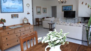 Una sala de estar con sofá, mesa de centro, televisor y chimenea.