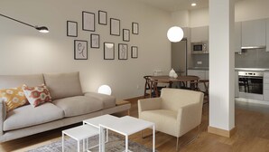 Ein modernes Wohnzimmer mit Sofa, Couchtisch und Essbereich mit Tisch und Stühlen.