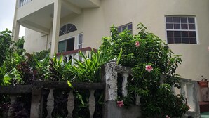 A two-story house with a balcony, a window, and a door.